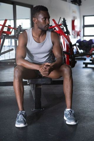 Fit African American Man Taking Break in Modern Gym