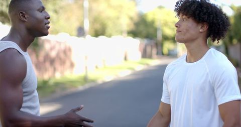 Diverse male friends enjoying casual outdoor chat on sunny day