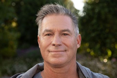 Middle-aged man relaxing in backyard garden under soft sunlight
