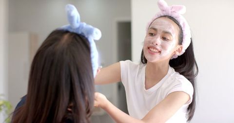 Teenage Girls Enjoying Spa Day with Facial Masks at Home
