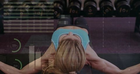 Overhead view of woman bench pressing dumbbells with digital fitness analytics overlay
