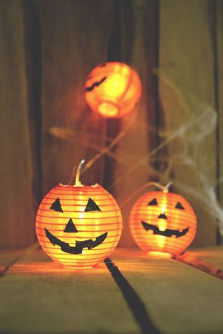 Glowing Halloween Pumpkin Lanterns on Wooden Background