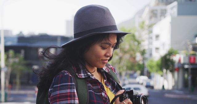 Woman enjoying traveling and taking photos in urban environment. Ideal for use in travel blogs, tourism promotional material, photography courses, lifestyle magazines, and advertisements highlighting travel gear and city explorations.