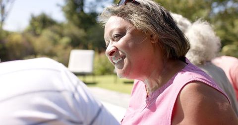 Smiling Senior Woman Cherishing Outdoor Moments with Friends in Garden
