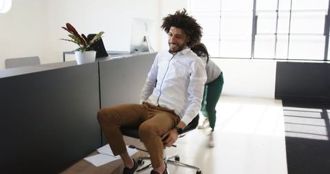 Coworkers Enjoying Playful Office Chair Race
