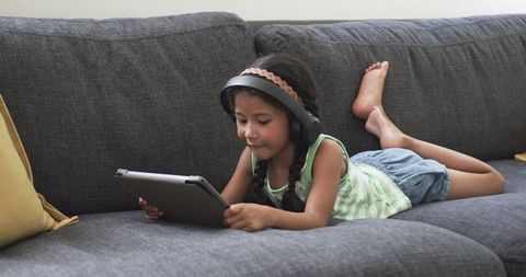 Young Girl with Headphones Enjoys Tablet on Comfortable Sofa - Download Free Stock Images Pikwizard.com