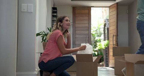 Young couple unpacking in new home during move