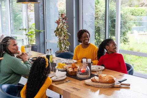 Multigenerational african american family sharing cozy brunch at sunlit dining table