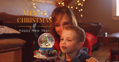 Mother and Son Enjoying Christmas Celebration with Snow Globe