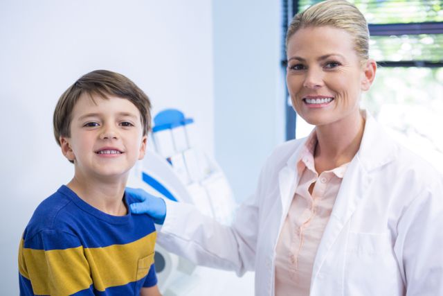 Portrait of happy dentist with boy at medical clinic