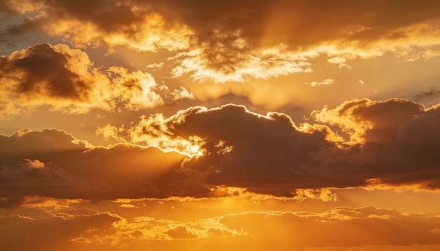 Golden sunbeams radiating through dramatic cumulus clouds during sunset