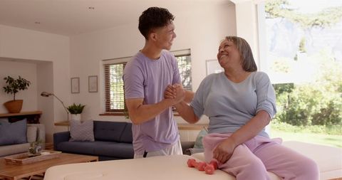 Male Physiotherapist Assisting Senior Woman with Arm Exercises