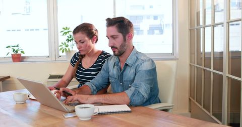 Focused Male-Female Team Collaborating in Modern Office with Laptop - Download Free Stock Images Pikwizard.com