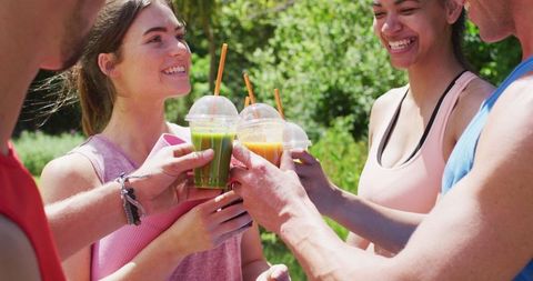 Joyful Friends Celebrating with Healthy Juices After Outdoor Exercise