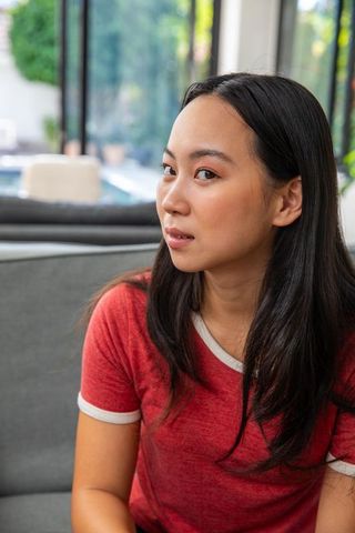 Contemplative woman in modern lounge relaxing at home
