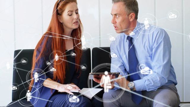 Business colleagues engaged in discussion with overlay of digital network connections in an office environment. Ideal for illustrating modern business communications, digital networks, teamwork, and technology in corporate settings.