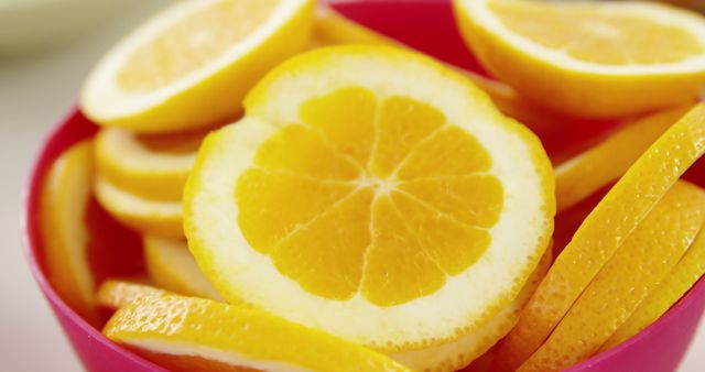 Brightly showcases lemon slices in a vibrant red bowl, highlighting freshness and potential as a healthy food choice or drink garnish. Ideal for use in culinary blogs, health and wellness articles, or advertisements promoting fresh and natural ingredients.