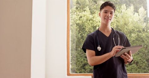 Confident Male Nurse Utilizing Tablet in Healthcare Setting