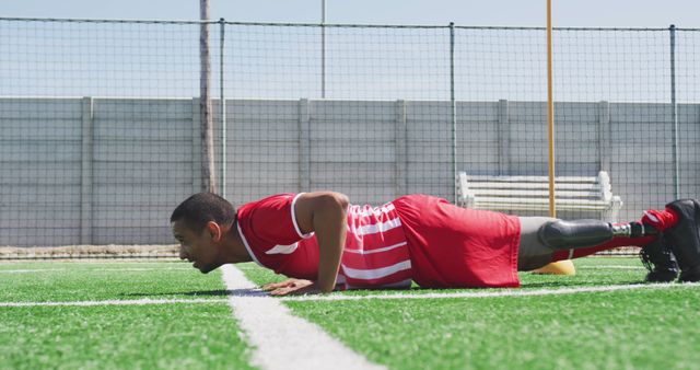 Determined male athlete with prosthetic leg doing push-up on soccer field - Download Free Stock Images Pikwizard.com