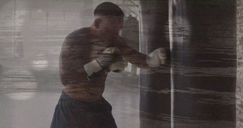 Boxer delivering powerful punch to heavy bag during intense gym training session