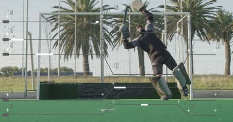 Goalkeeper making a diving save on field hockey turf