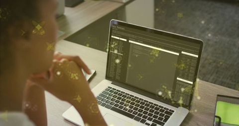 Woman Analyzing Cybersecurity Data on Laptop at Office Desk