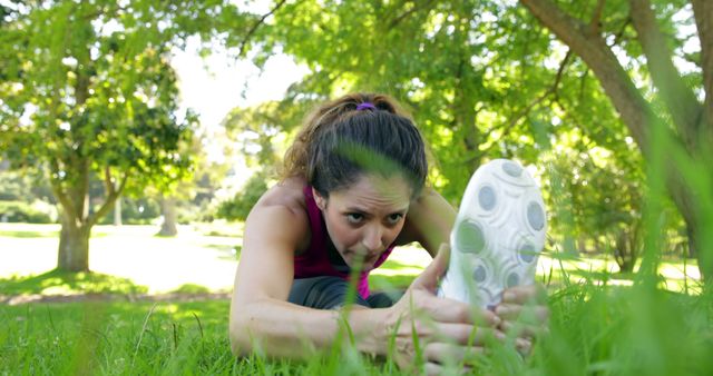 Woman stretching her legs before a jog in the park on a sunny day - Download Free Stock Photos Pikwizard.com