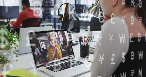 Businesswoman Videocalling at Modern Office with Currency Symbols Overlay