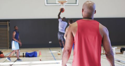 Coach Supervising Basketball Team During Practice Session Indoors