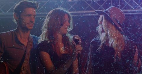 Energetic Band Performing with Snow and Lights on Stage