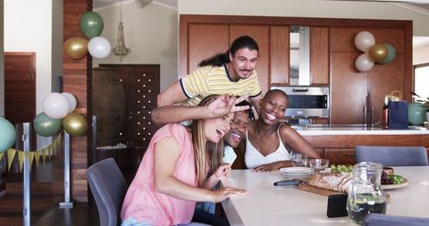 Friends Gathering in Kitchen Celebrating Happy Moments Together