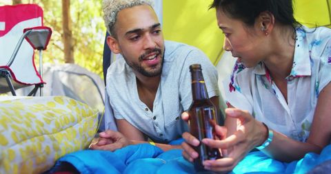 Friends relaxing with beer during camping adventure