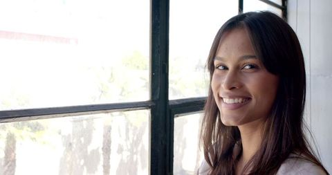 Confident Woman Smiling by Office Window