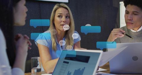 Blonde leader guiding team meeting with laptops and analytics charts for team planning