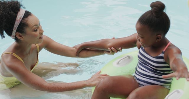 Mother Hugging Daughter in Swimming Pool with Inflatable Ring - Download Free Stock Images Pikwizard.com