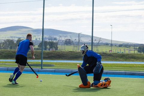 Field Hockey Competition Showing Player Dribbling with Goalkeeper