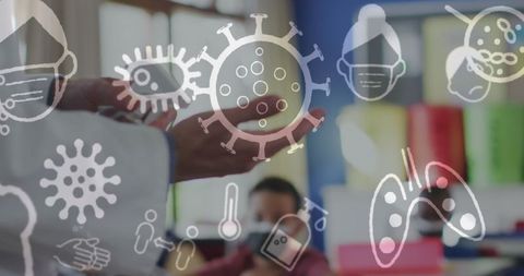 Doctor disinfecting hands with covid-19 icons overlaid in classroom