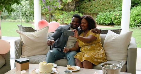 African American Couple Enjoying Dessert and Smartphone in Cozy Living Space