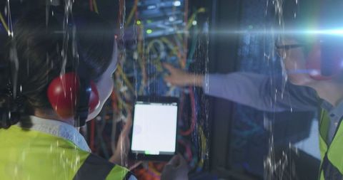 Engineers managing data center with high tech interface