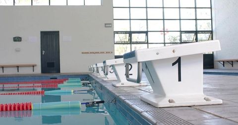 Closeup starting block number 1 on indoor competition pool deck with calm lanes