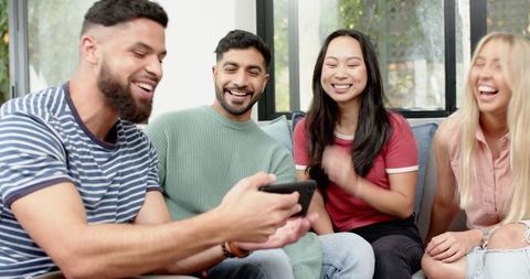 Diverse Friends Laughing and Socializing with Smartphone
