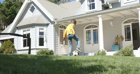 Boy practicing soccer skills on suburban lawn with augmented coaching overlays