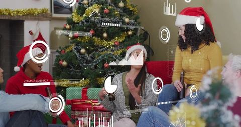 Friends chatting and laughing at holiday gathering by christmas tree with gifts