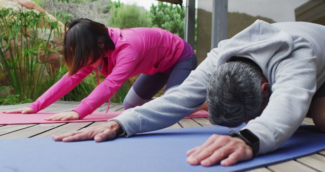 Happy diverse couple doing yoga, stretching on yoga mat at terrace - Download Free Stock Photos Pikwizard.com