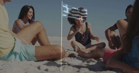 Diverse friends relaxing at beach with flag and summer attire