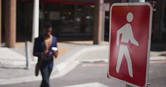 Out-of-Focus Pedestrian Walking Across Street with Sign, Urban Daylight - Download Free Stock Images Pikwizard.com