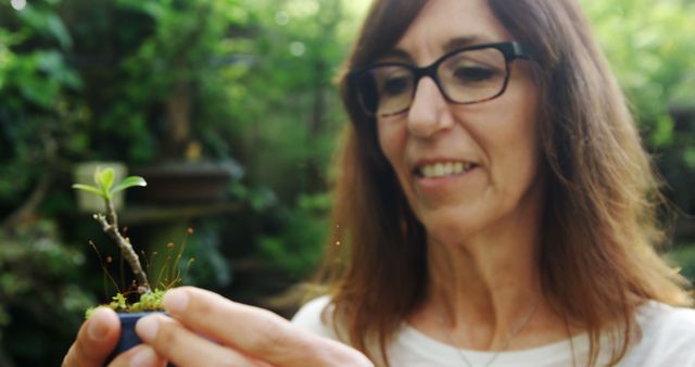 Smiling Woman Admiring Tiny Plant in Hand Outdoors - Download Free Stock Images Pikwizard.com