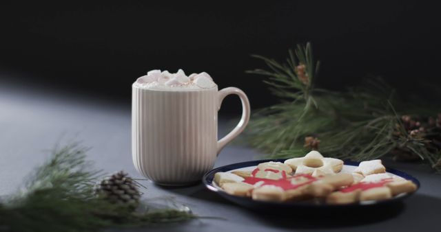 Traditional hot chocolate surrounded by gingerbread cookies and pine branches. Ideal for representing holiday themes, celebrating Christmas, promoting seasonal warm drinks, and enhancing winter festive settings.