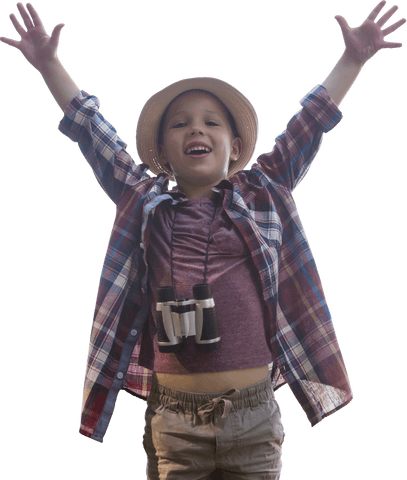 Cheerful boy in plaid shirt raising arms with binoculars