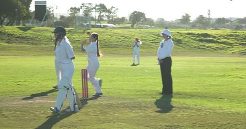 Women playing cricket match with focus on strategy and teamwork